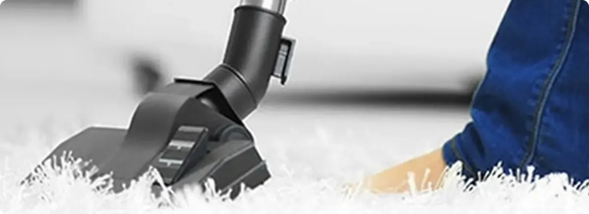 Close-up of a professional vacuuming a white carpet in Wilmington.